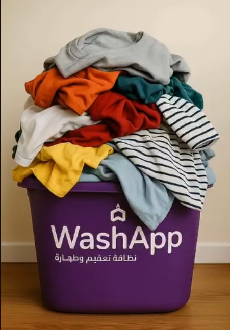 A purple WashApp laundry basket piled high with colourful clothes, ready for pickup in Kuwait